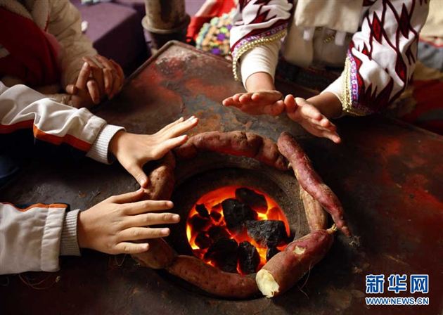 放学后,爱心互助小组的学生们聚到苗寨小学一名学生家里,在炉边烤红薯